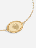 TAYLR gold oval rope bracelet featuring a personalised engraved heart made from two fingerprints and initials L&M.