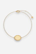 TAYLR gold oval rope bracelet with a polished engravable surface and delicate chain on a light background.
