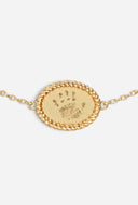 TAYLR gold oval rope bracelet featuring a delicate engraved child handprint on a polished metal charm